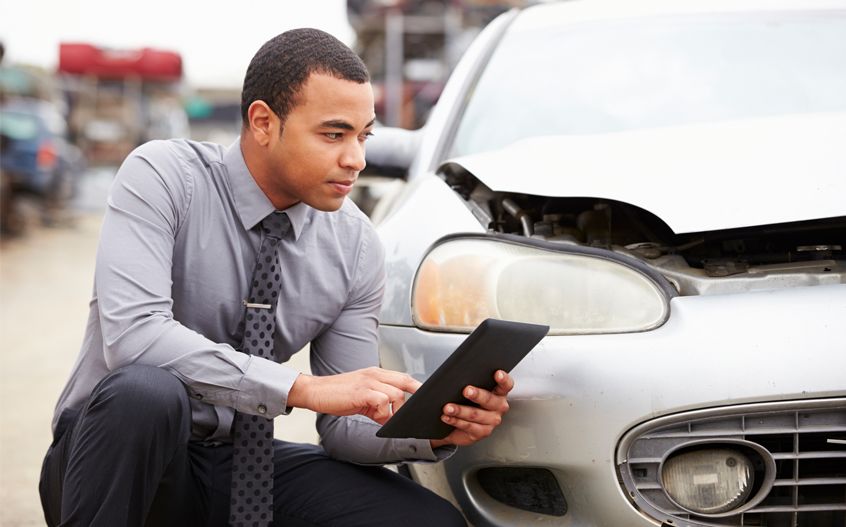 Insurance Adjuster Looking at Car