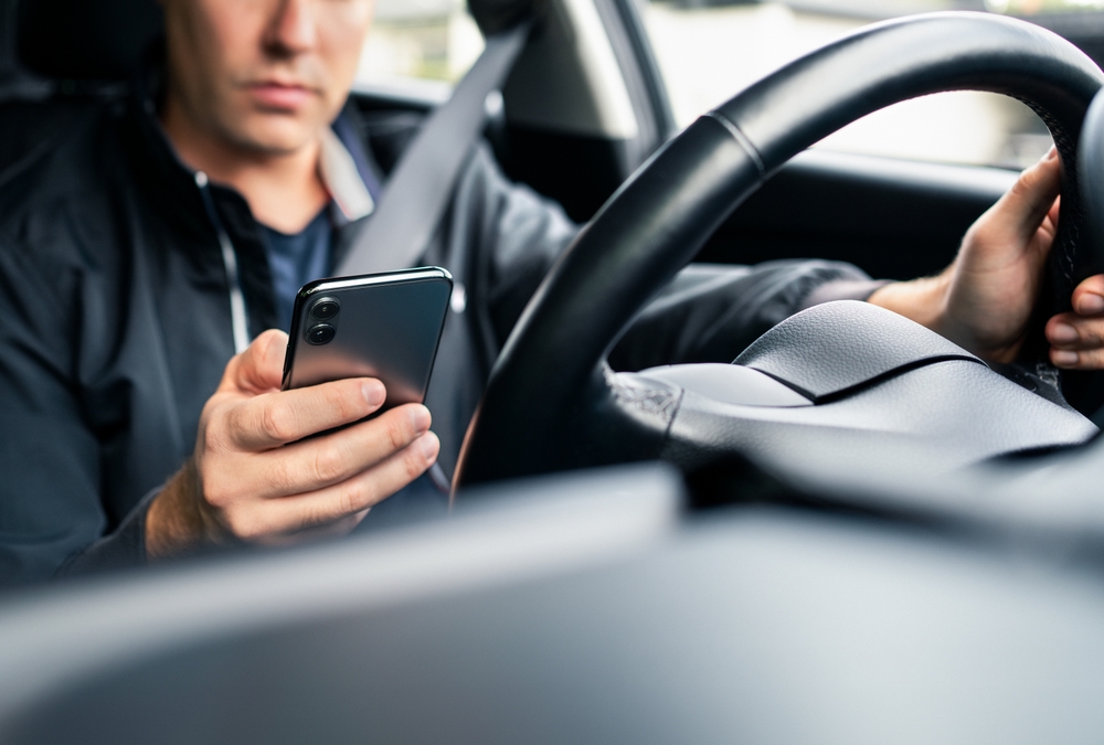 Man driving distracted by phone.