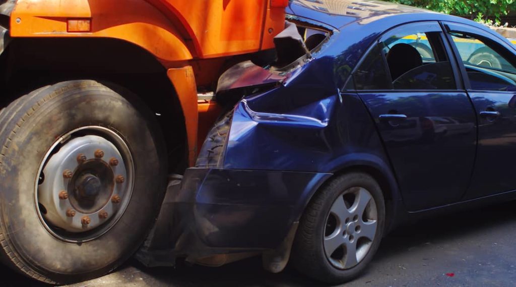 a car is crushed in a truck accident | The Law Offices of Mickey Fine