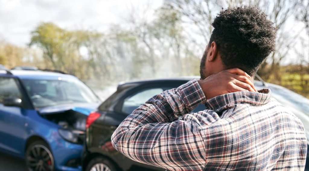 man rubs neck after a car accident | The Law Offices of Mickey Fine