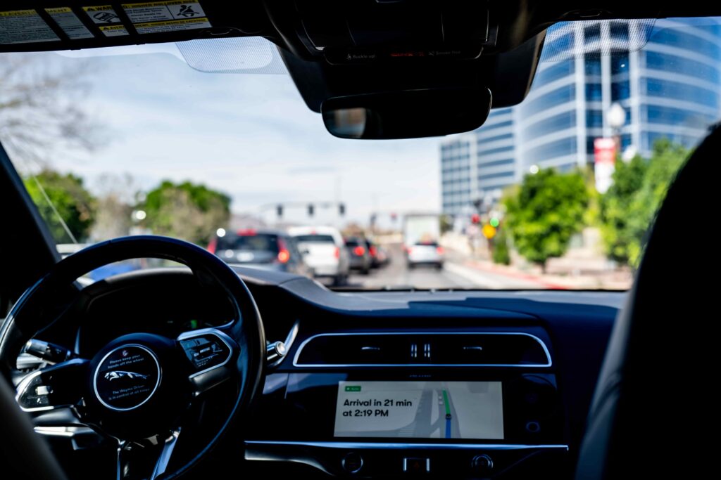 Interior view of a modern car driving through city traffic with navigation screen showing ETA