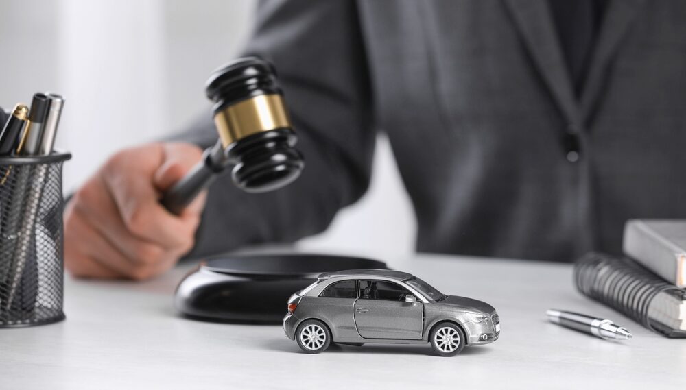 Bakersfield car accident lawyer with gavel and toy car symbolizing legal action