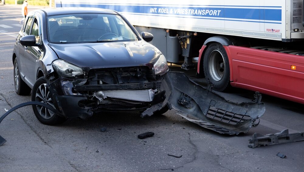 Front-end car damage after collision with commercial truck in Bakersfield, California