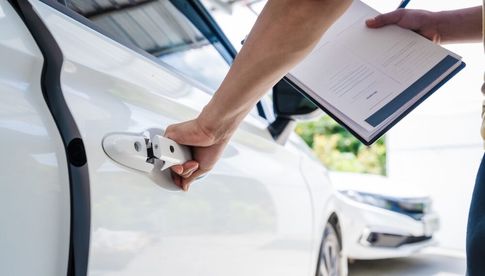 Insurance adjuster inspecting car door after accident in Bakersfield