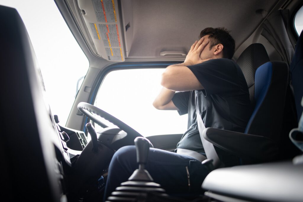 View from inside a commercial truck cab on a long Bakersfield highway, highlighting risks of truck driver fatigue and HOS violations