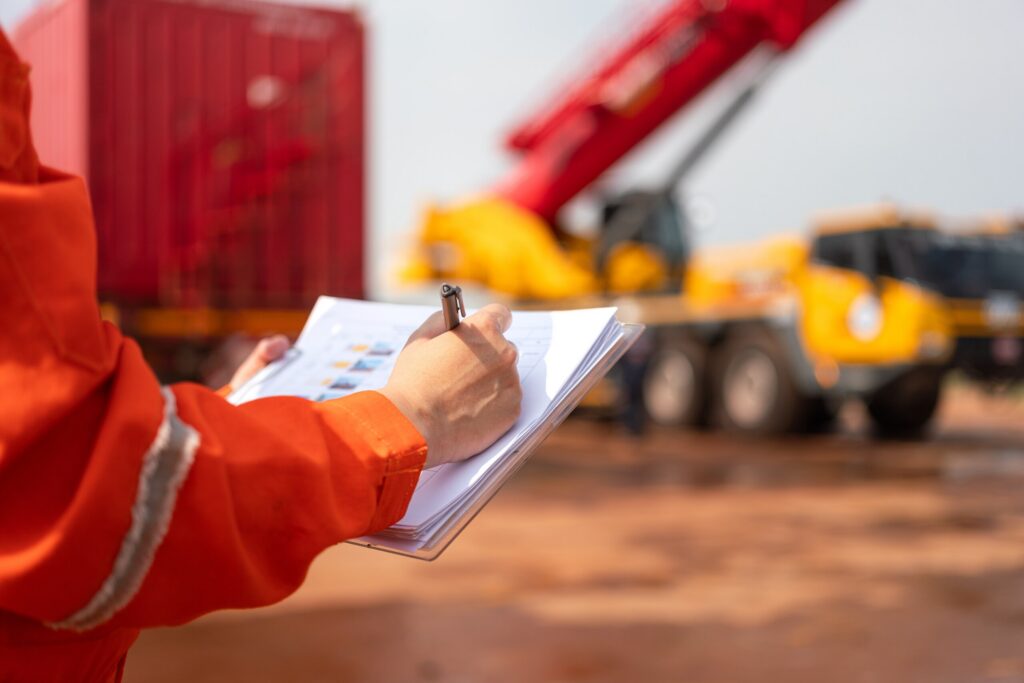 Un trabajador de la construcción rellenando una lista de comprobación de seguridad, como ejemplo de las pruebas de la inspección de la obra utilizadas por los abogados especializados en accidentes con andamios de Bakersfield.