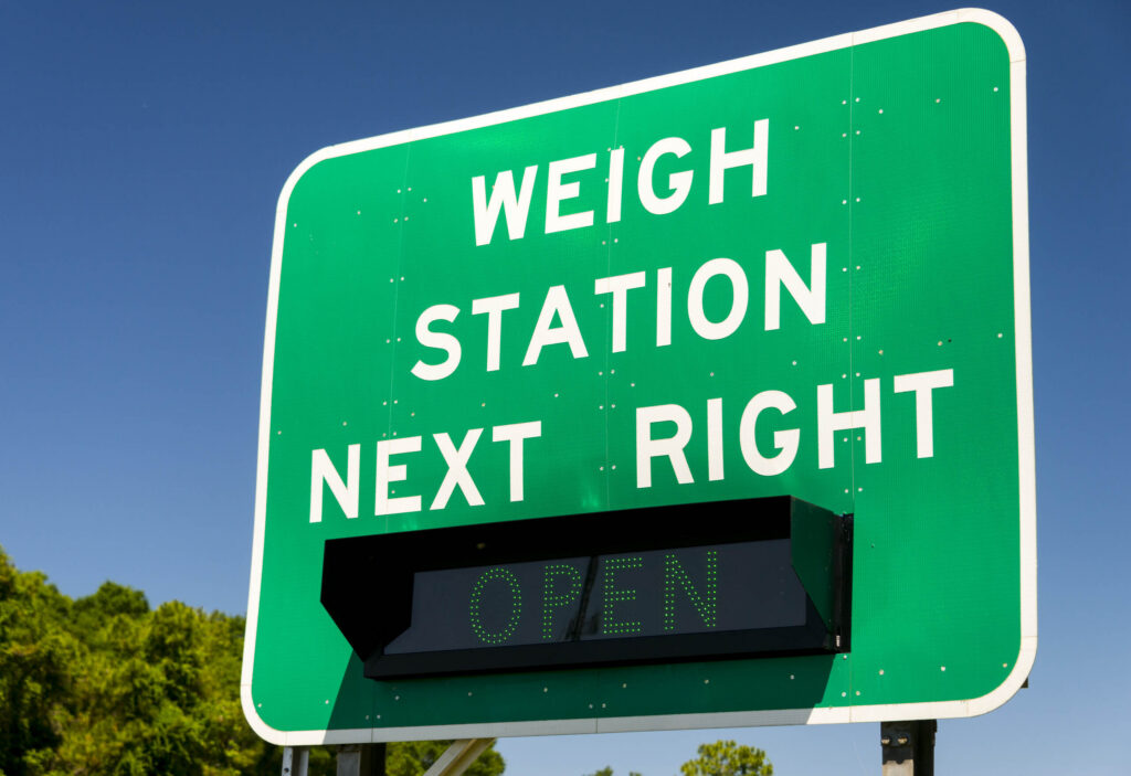 A green weigh station next right sign highlights mandatory commercial vehicle checks to reduce Weigh Station Violations in Bakersfield Truck Accidents.