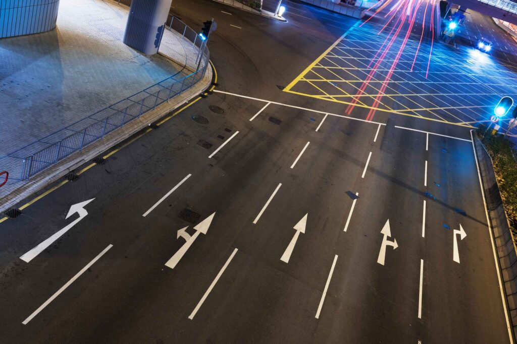 Multi lane city roadway with direction arrows highlighting fault and lane splitting how Bakersfield motorcycle accidents are handled.