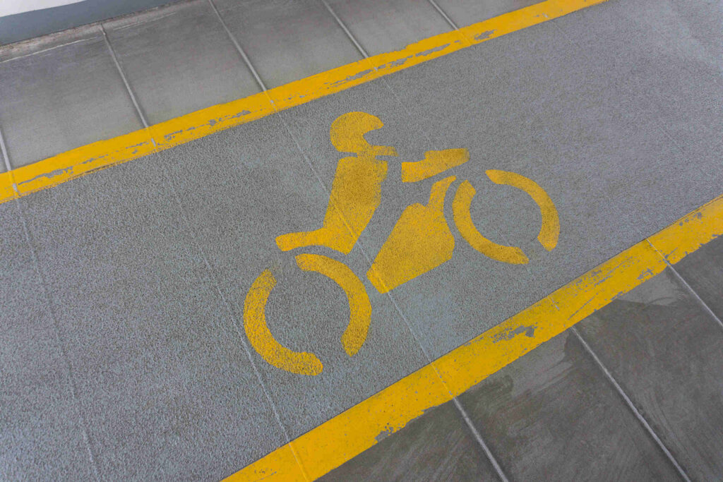 Yellow painted motorcycle stencil on asphalt demonstrating fault and lane splitting how Bakersfield motorcycle accidents are handled.