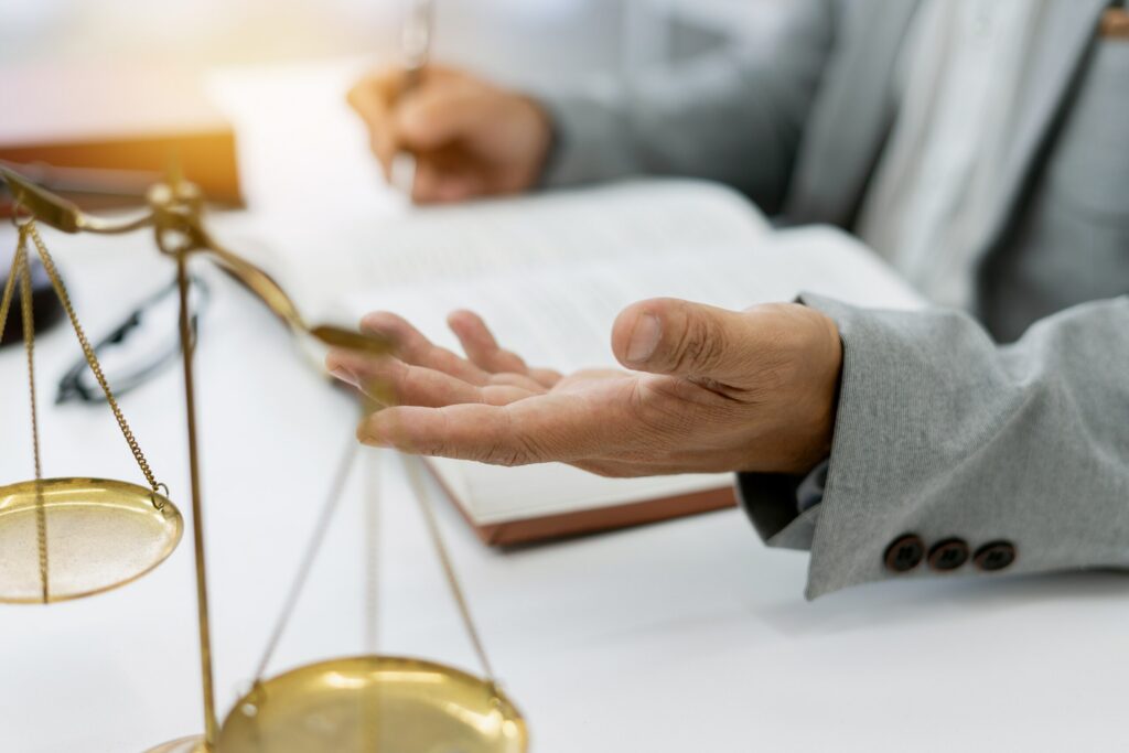 Attorney writing in a law book next to scales of justice explaining what to expect at your California personal injury deposition.